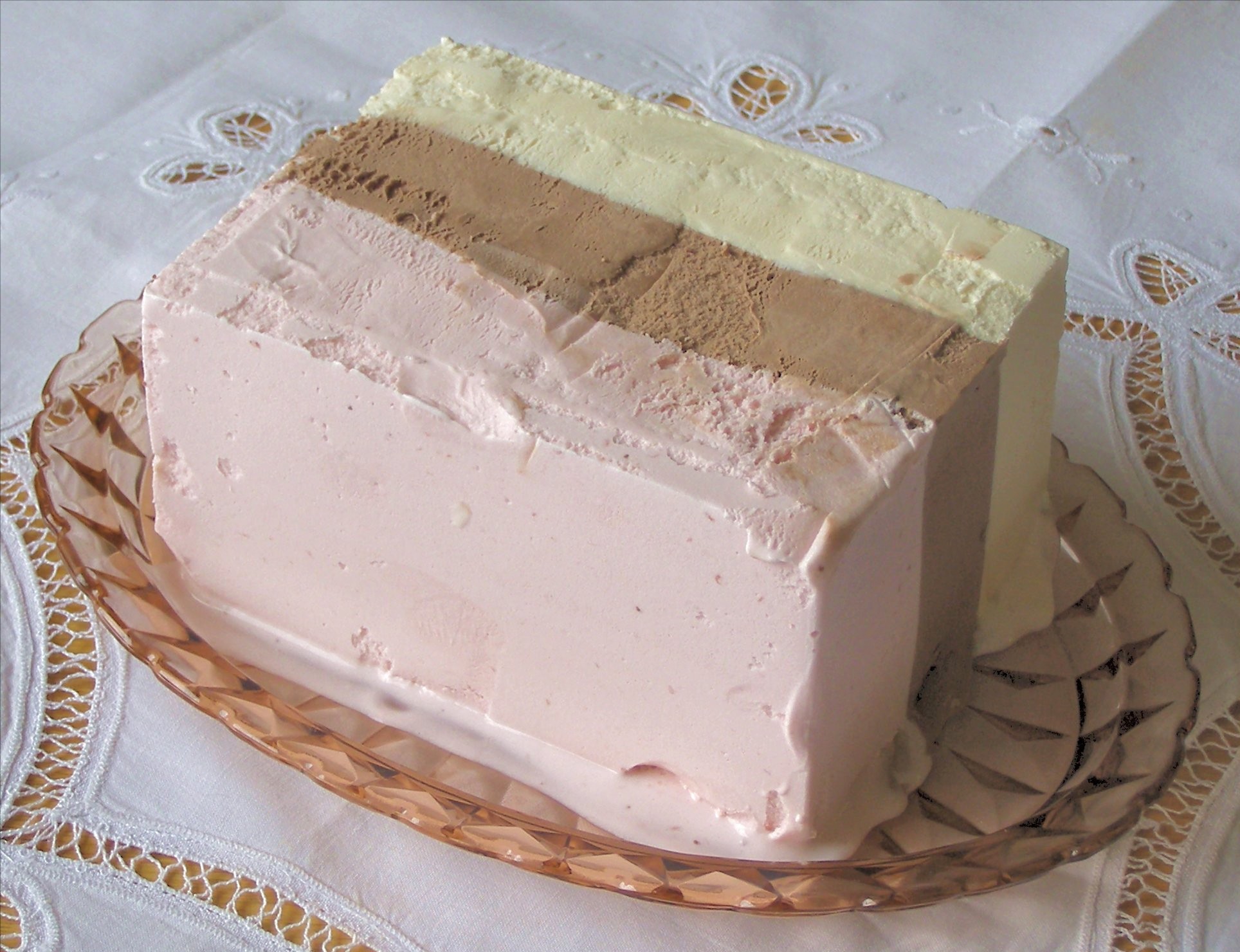 an ice cream composed of three separate flavors (typically vanilla, chocolate, and strawberry) arranged side by side in the same container, usually without any barrier between them